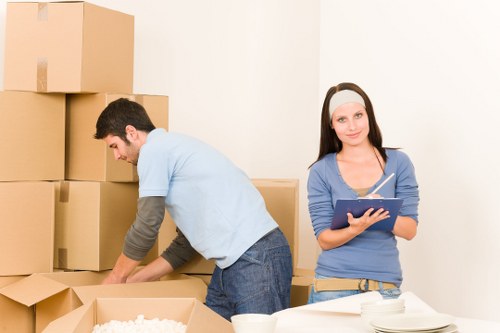Removal team handling furniture and boxes in a Mitcham property